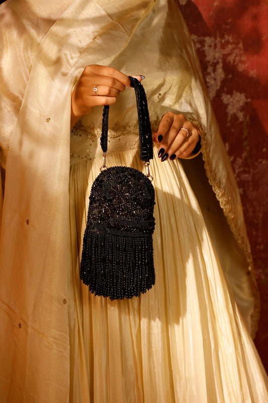 Designer black clutch styled with a lehenga for sangeet
