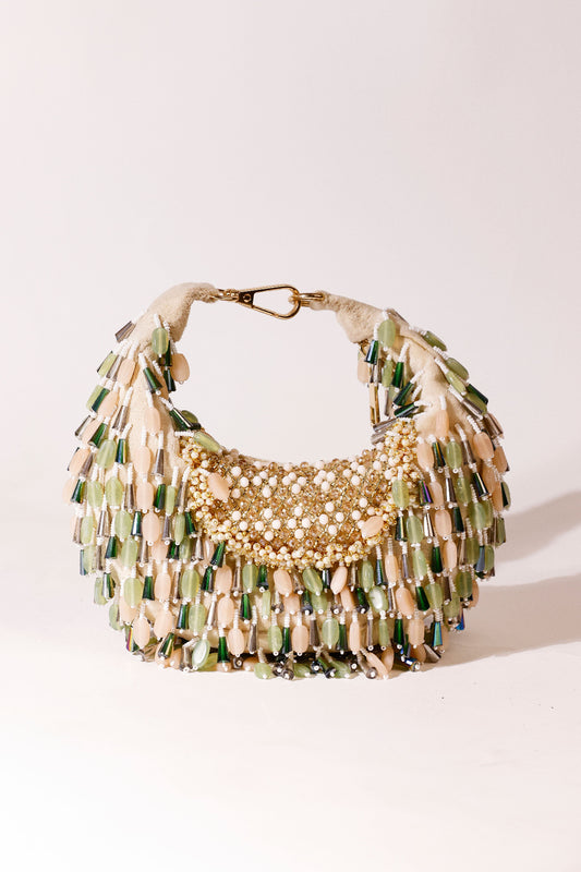 Sculptural hobo accessory combining earthy tones with shimmering embellishments