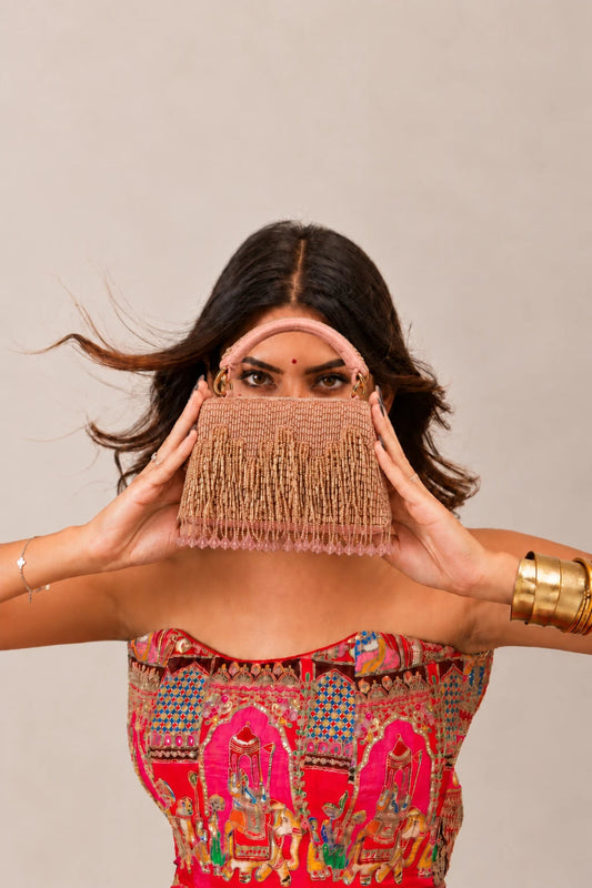 Luxury pink fringe bag featuring intricate embellishments and statement craftsmanship