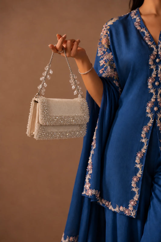 Designer white handbag featuring handcrafted crystal and bead embellishments with an elegant contemporary finish.