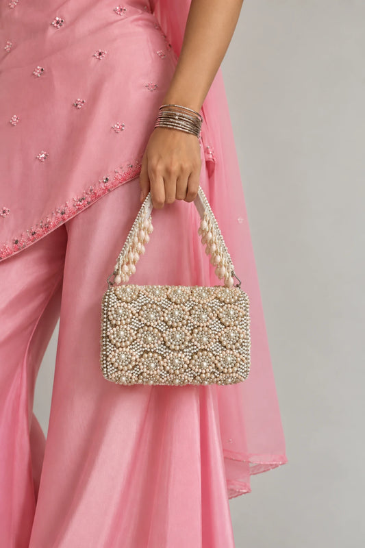 Designer white pearl handbag with delicate handcrafted bead embellishments and an elegant statement finish.