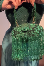 Emerald green cocktail handbag with intricate bead embellishments and cascading fringe detailing