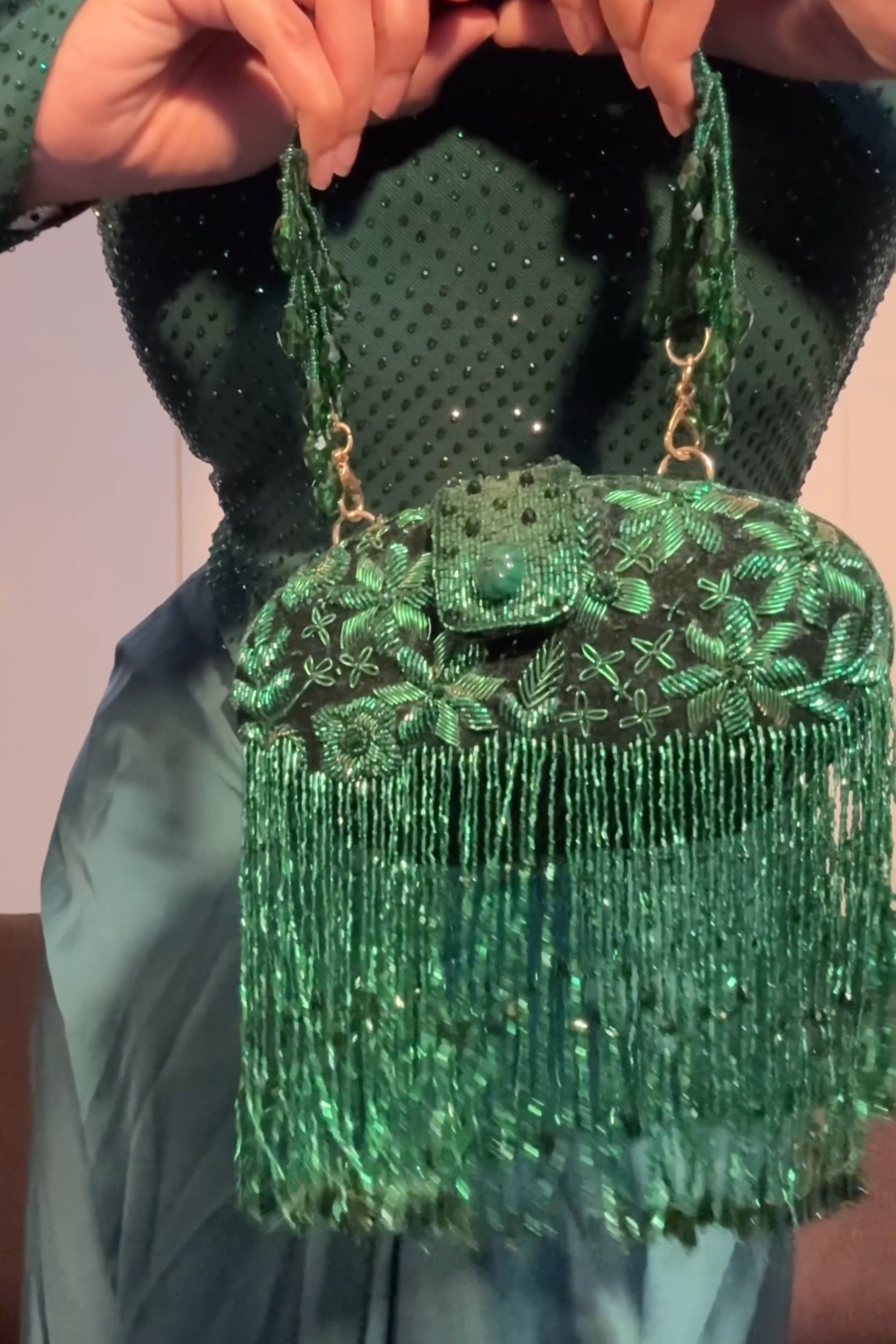 Emerald green cocktail handbag with intricate bead embellishments and cascading fringe detailing