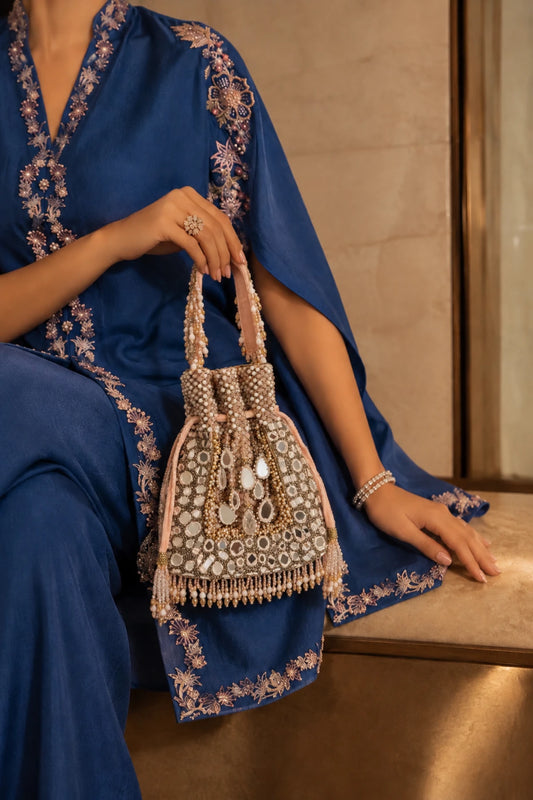 Designer baby pink potli bag with intricate mirror detailing and handcrafted embellishments for festive occasions.
