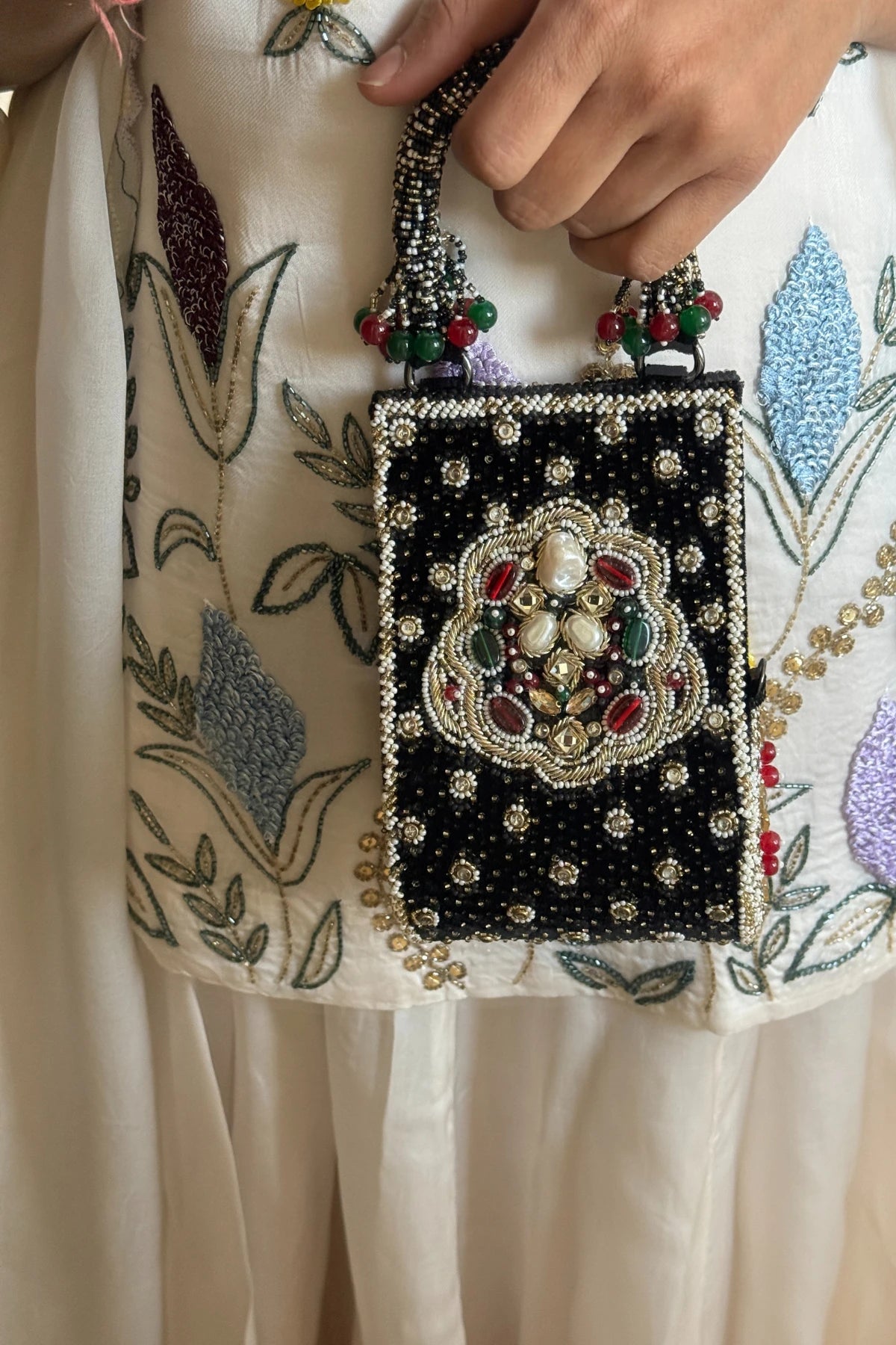 Black clutch bag paired with a silk saree for festive celebrations