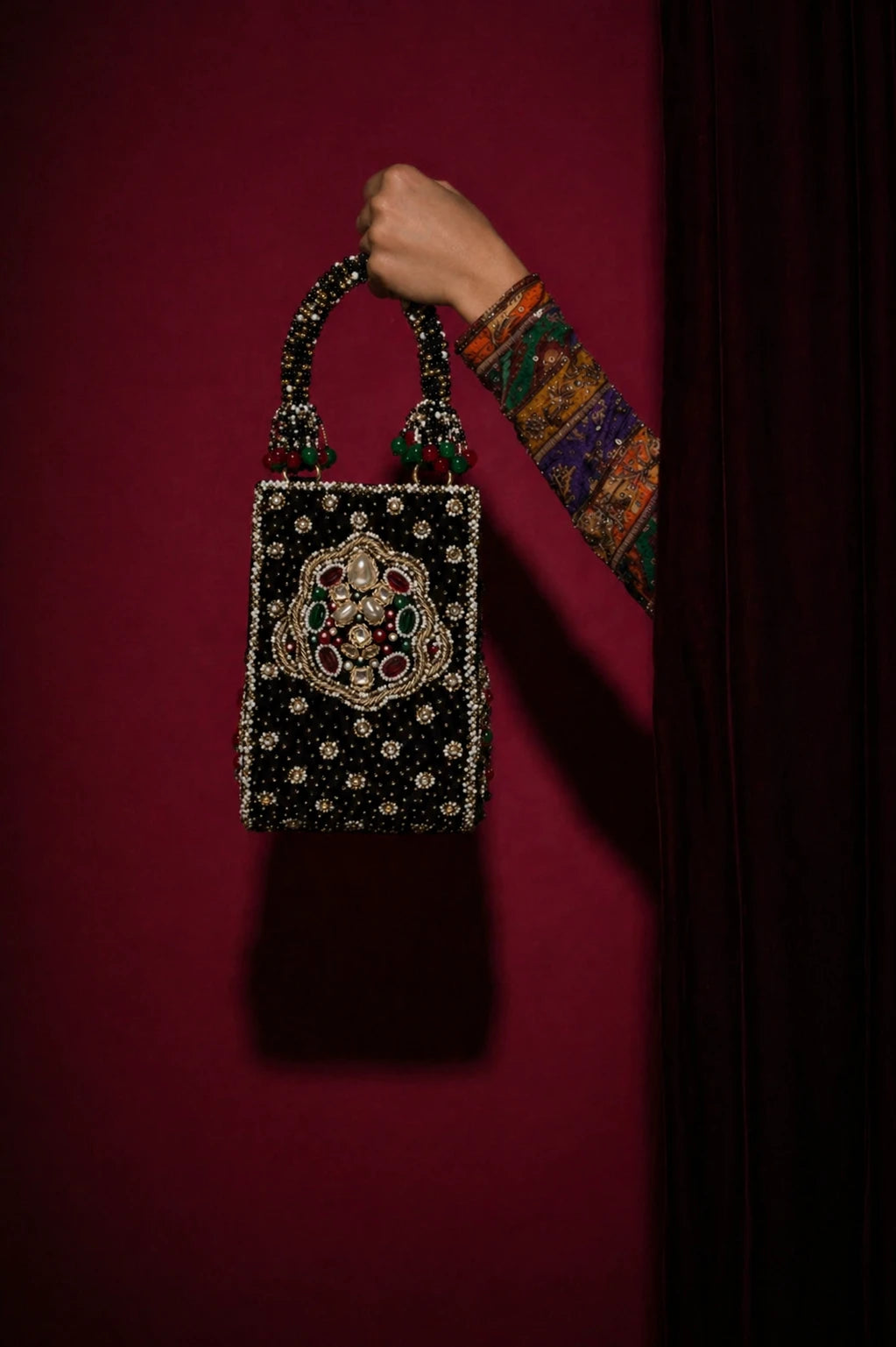 Designer black clutch bag styled with ethnic wear