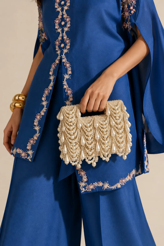 Dewdrop Pearl Clutch featuring cascading white pearls and oversized teardrop pearl embellishments on a golden base, perfect for Haldi celebrations.