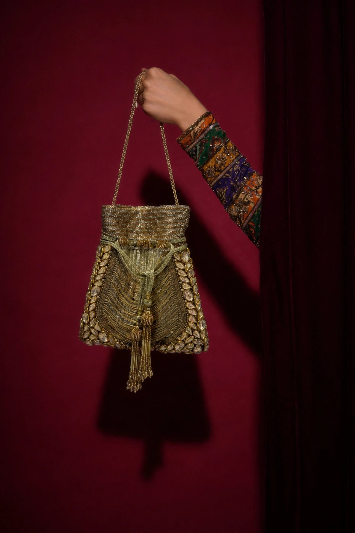 Gold beaded potli styled with a festive wedding lehenga