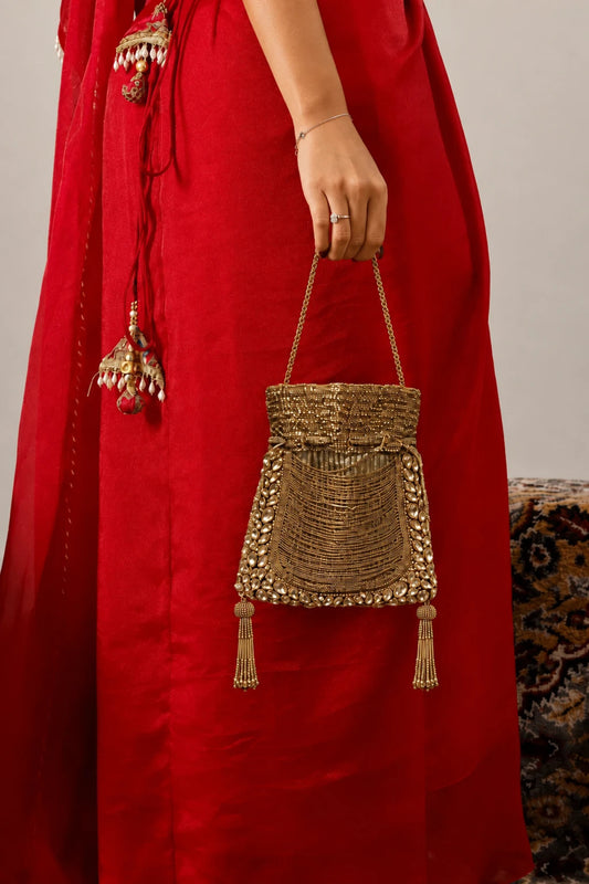 Gold beaded potli styled with a festive wedding lehenga