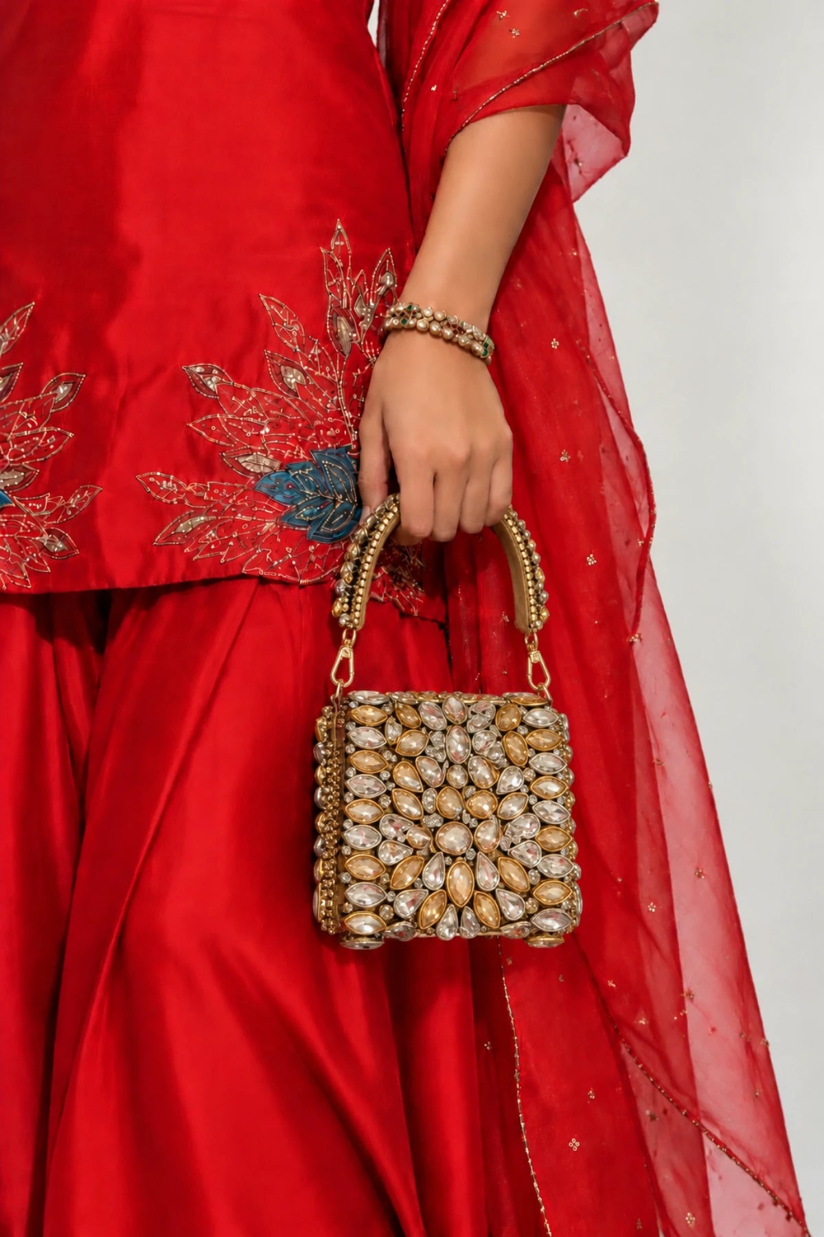 Designer gold and silver mini handbag with elaborate kundan-inspired embellishments and a structured silhouette.