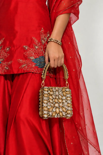Designer gold and silver mini handbag with elaborate kundan-inspired embellishments and a structured silhouette.