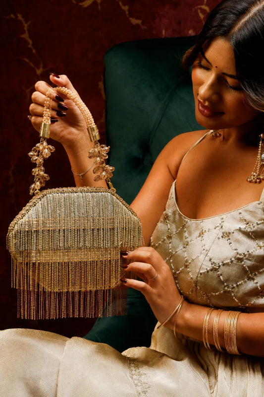 Designer golden clutch styled with a wedding lehenga
