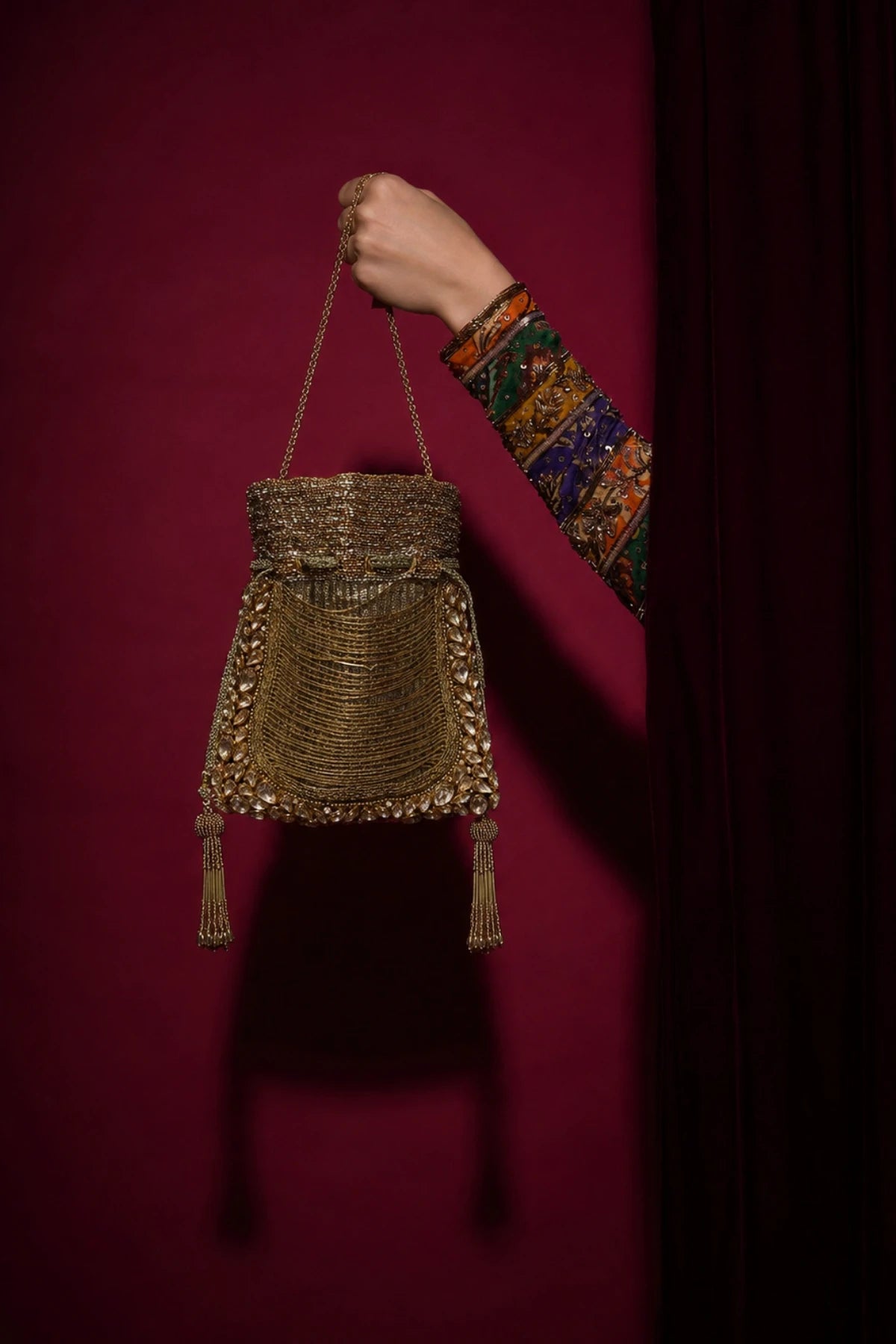 Golden potli bag paired with a saree for a wedding celebration