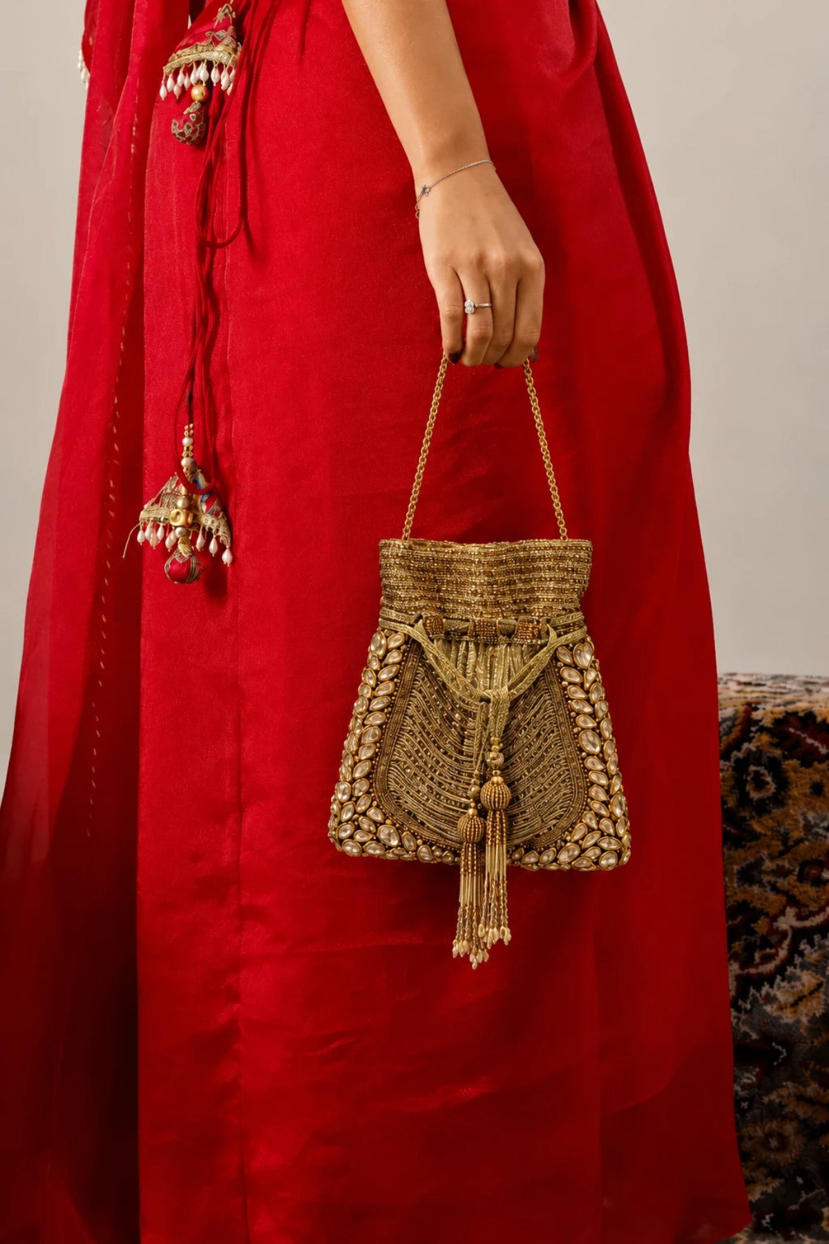 Golden potli bag paired with a saree for a wedding celebration