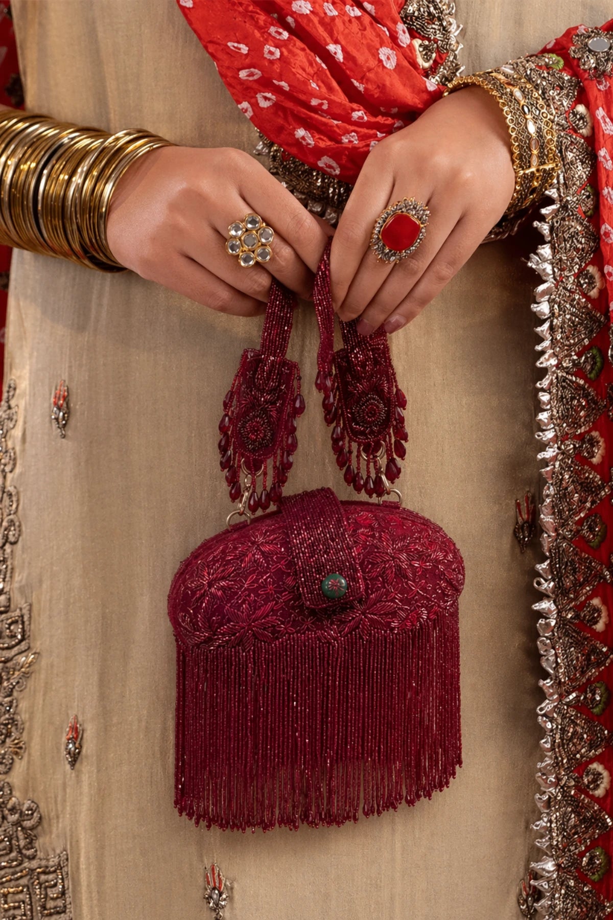 Handcrafted red clutch with intricate beadwork and flowing fringe