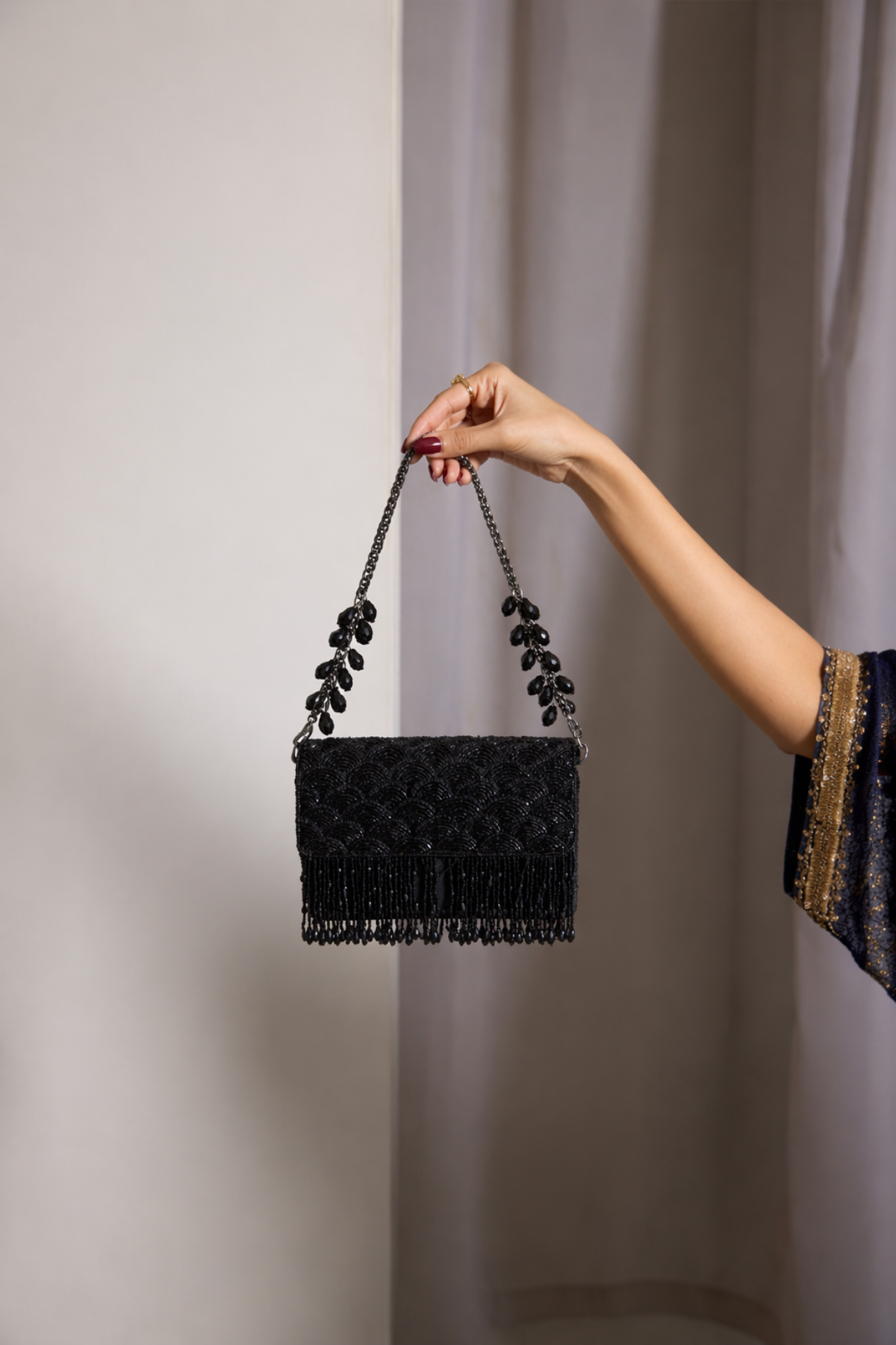 Black chain occasion handbag with textured beadwork and cascading fringe accents