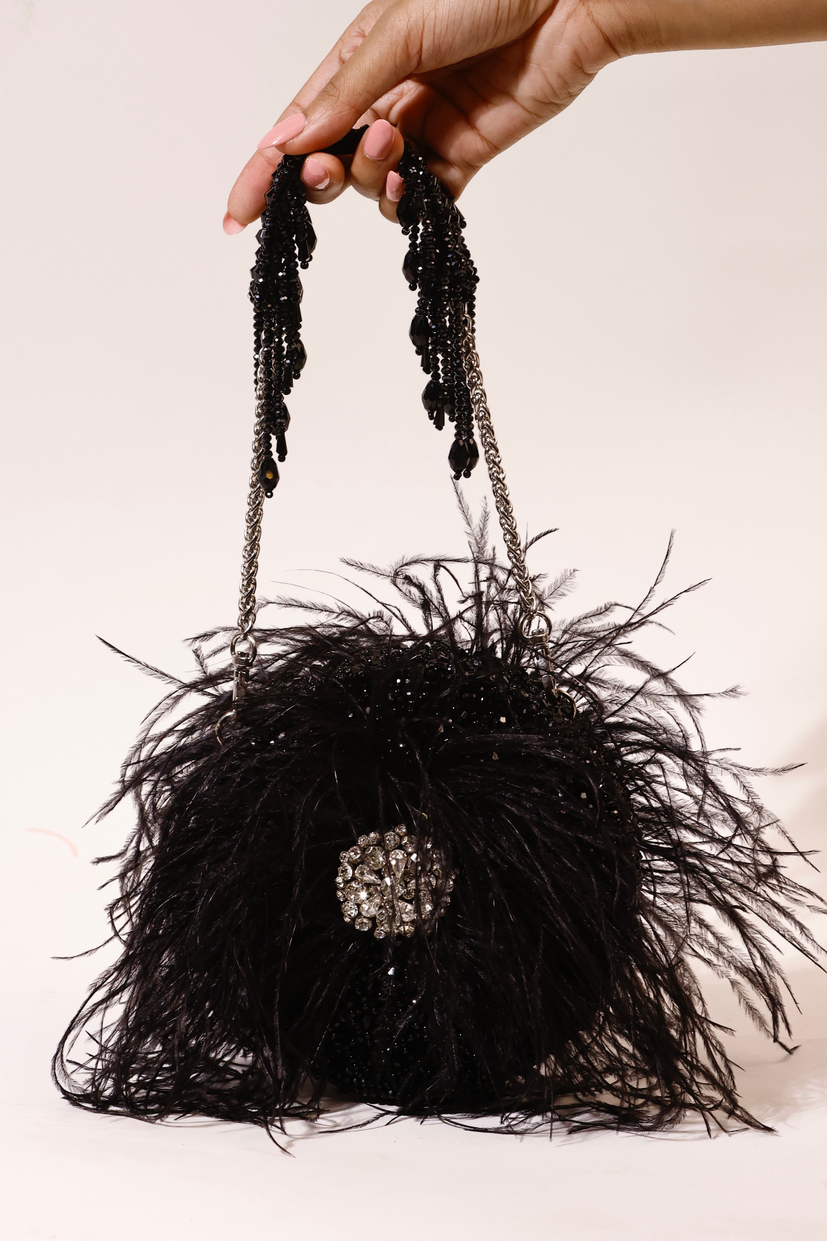 Statement black purse featuring voluminous feathers and handcrafted detailing
