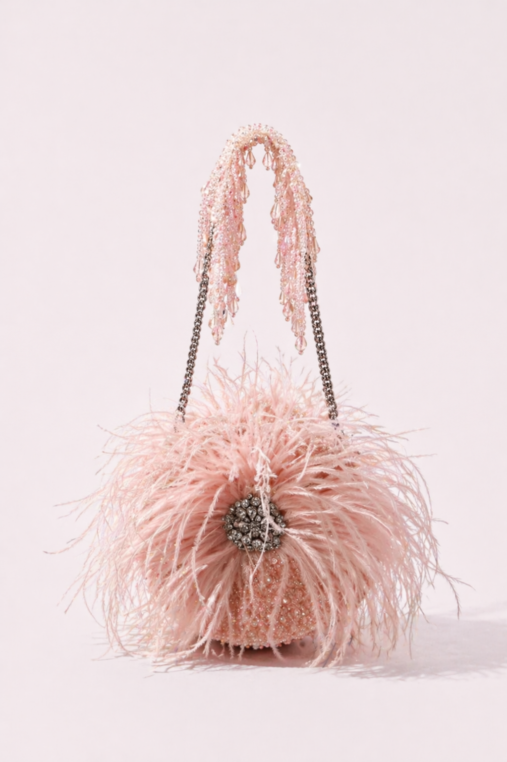 Blush pink feather handbag with sparkling embellishments and dramatic texture