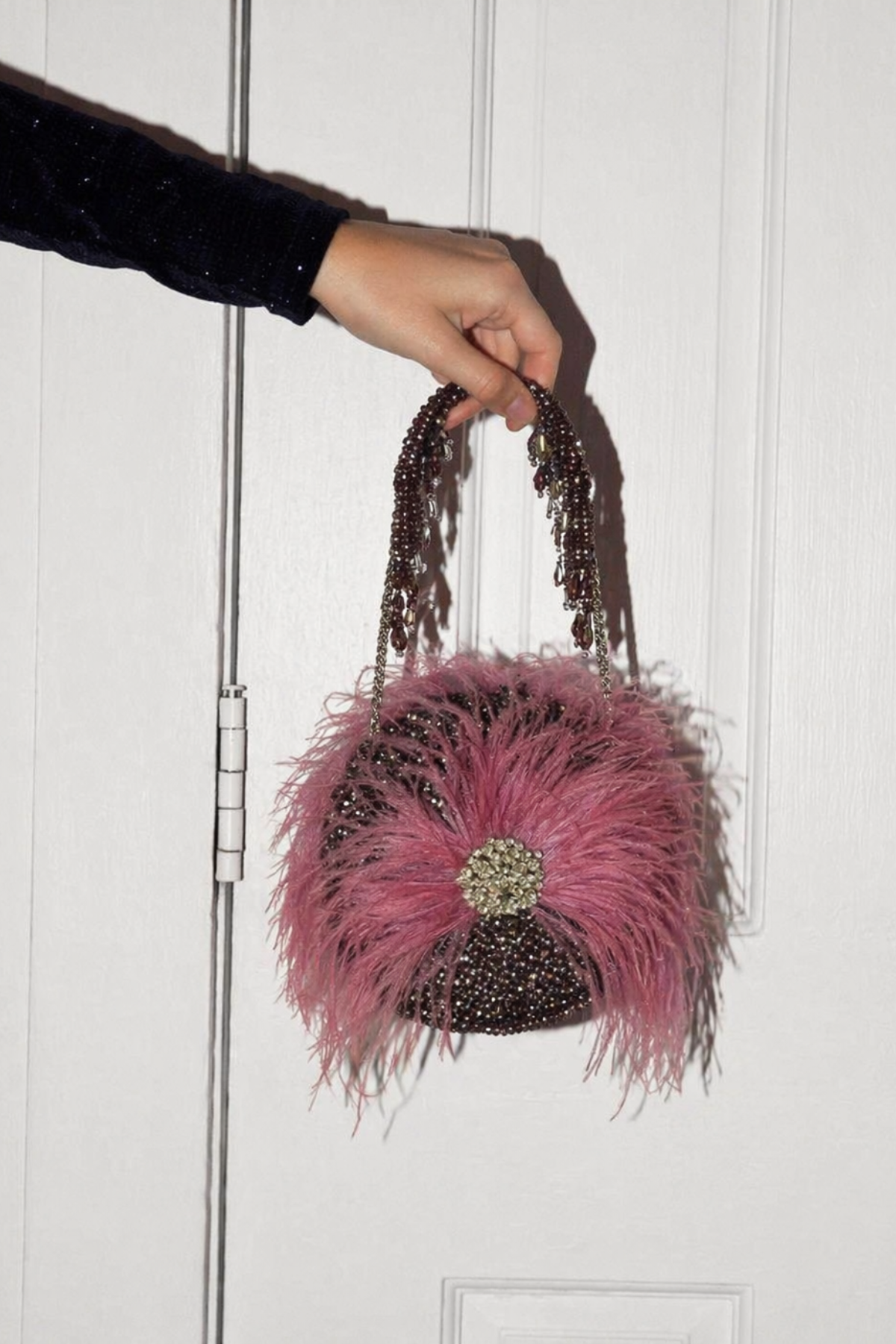 Feather embellished party purse with soft texture and elegant crystal accents