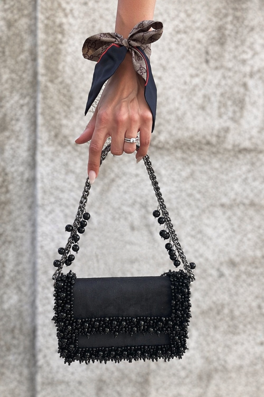 Gift-worthy black handbag featuring luxe embellishments and timeless festive appeal