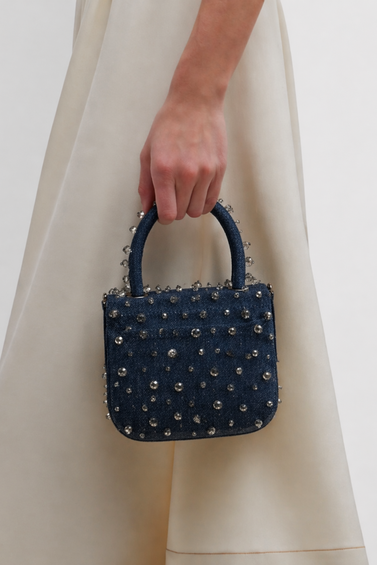 Gift-worthy denim handbag featuring statement crystal embellishments and festive glamour