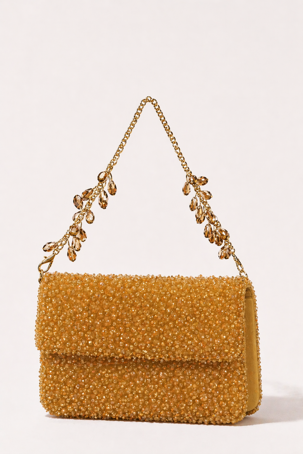 Gold handbag featuring rich bead texture and delicate crystal chain accents