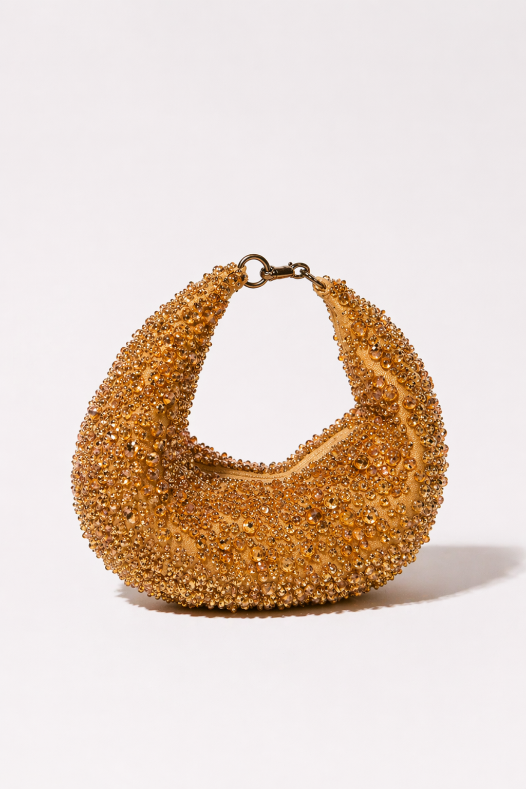 Gold beaded hobo bag with shimmering crystal embellishments and sculptural shape