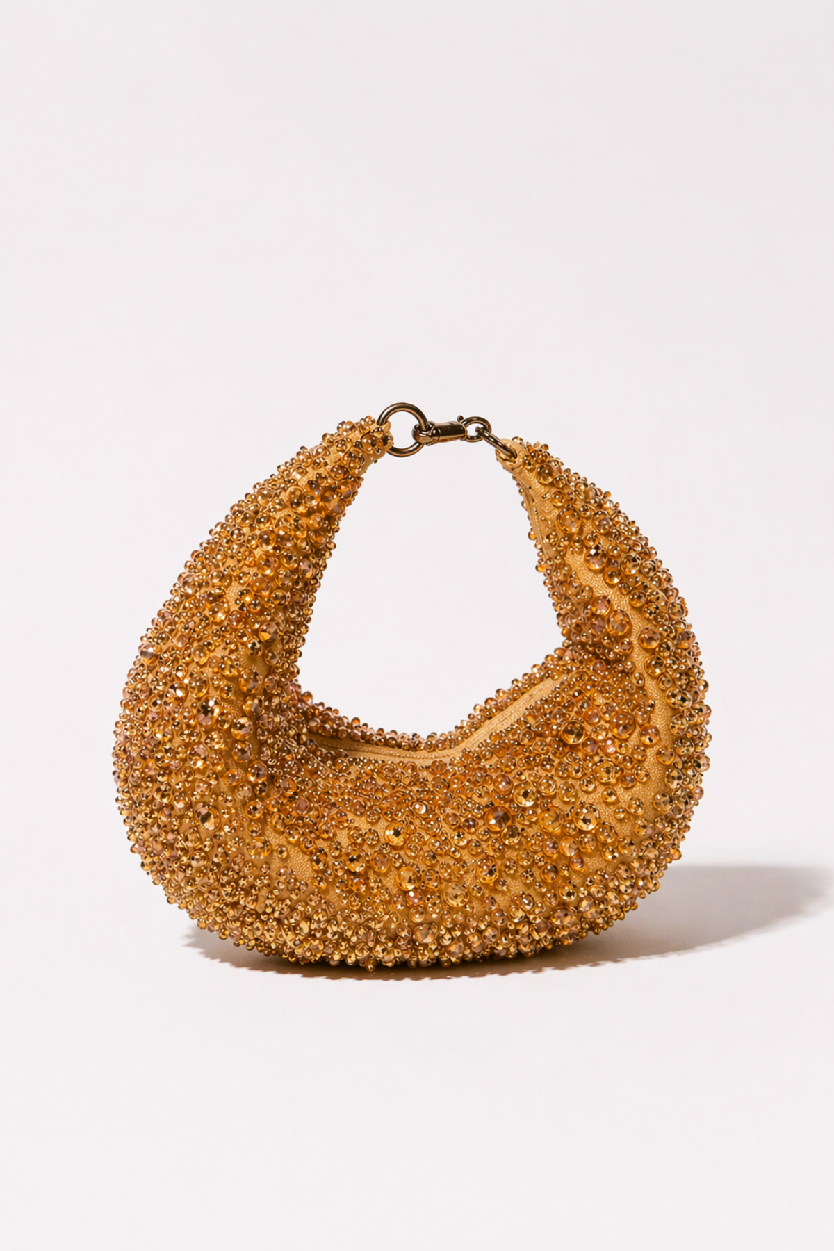 Gold beaded hobo bag with shimmering crystal embellishments and sculptural shape