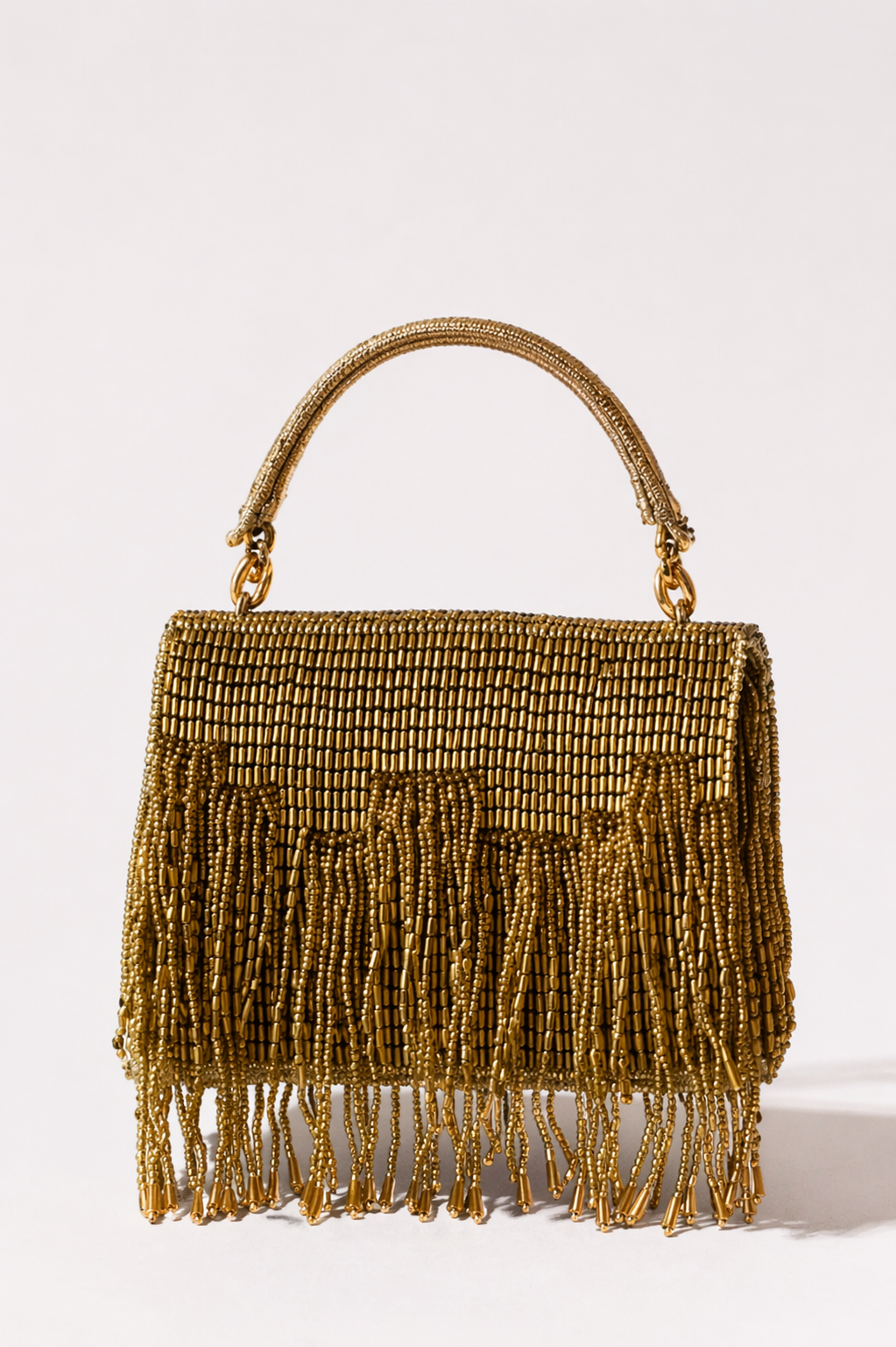 Gold trousseau clutch with shimmering fringe detailing and elegant handcrafted texture