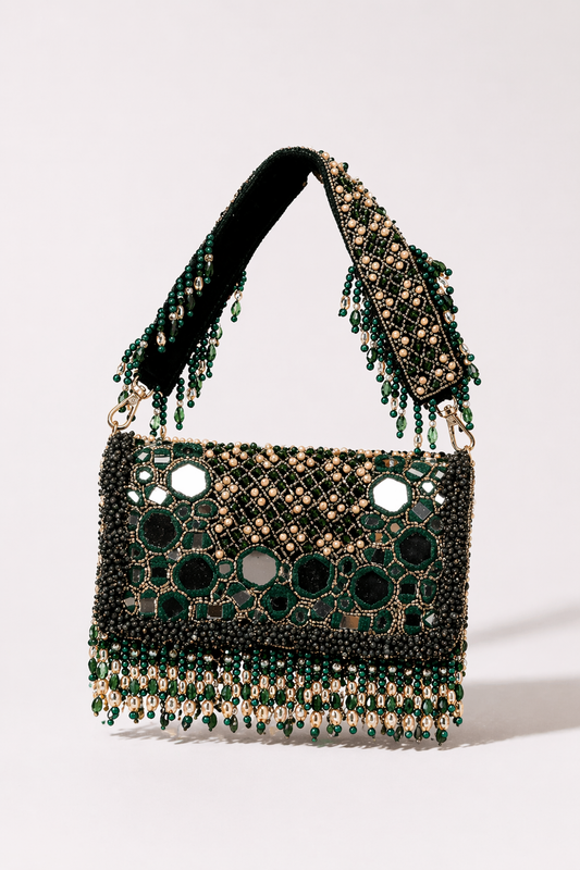 Green mirror work handbag with intricate stone embellishments and festive tassel detailing