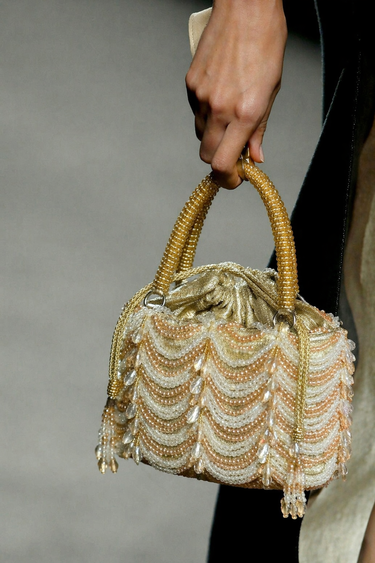 Luxury gold wedding guest bag featuring layered pearl embellishments and elegant texture
