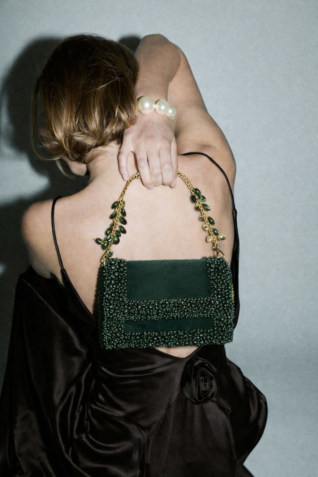 Luxury green party purse featuring handcrafted stone embellishments and rich texture