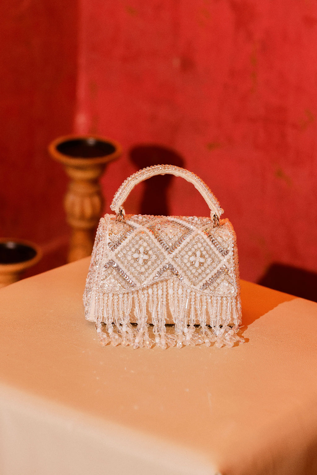 White occasion bag with shimmering fringe accents and artisanal craftsmanship