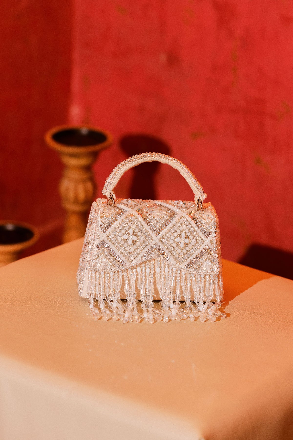 White occasion bag with shimmering fringe accents and artisanal craftsmanship