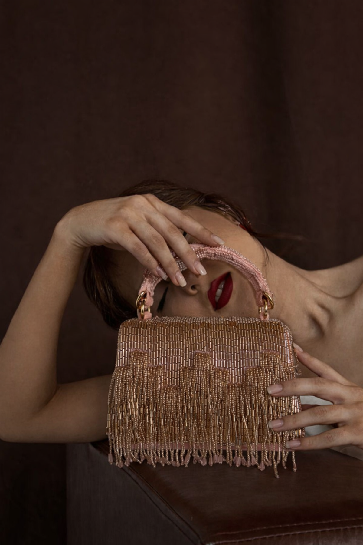 Luxury pink fringe bag featuring intricate embellishments and statement craftsmanship