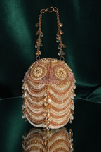Designer-style peach pearl handbag with intricate handcrafted detailing and festive styling