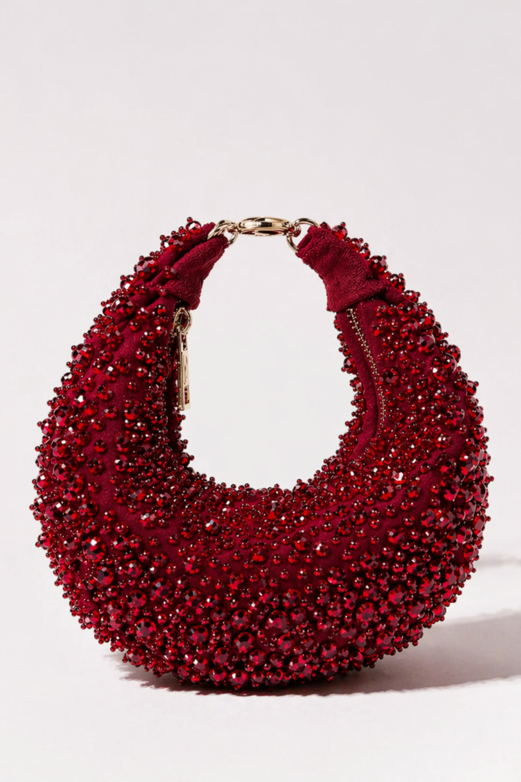 Red beaded hobo bag with rich crystal embellishments and sculptural silhouette