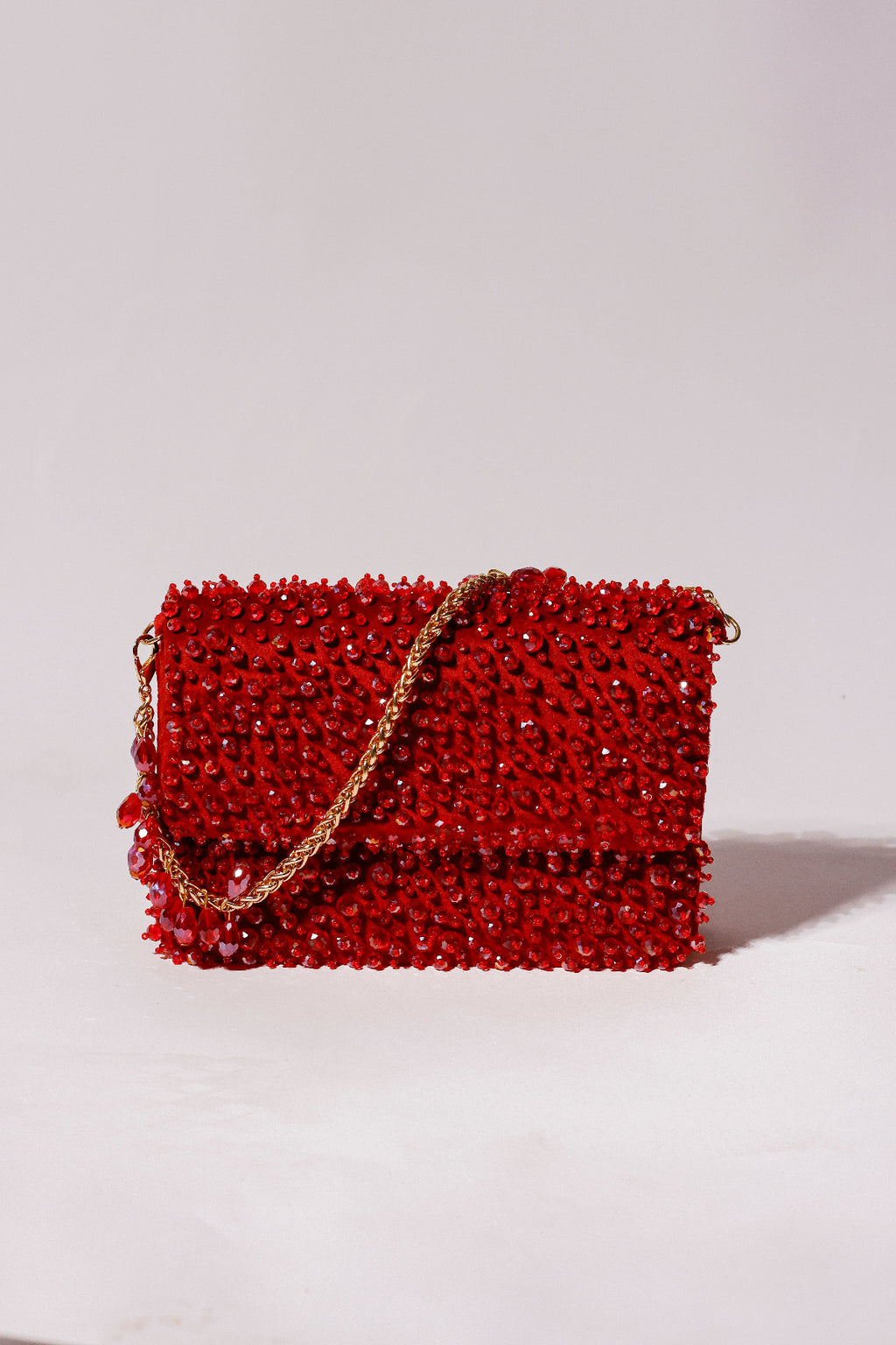 Red beaded handbag with a gold chain 
