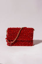 Red beaded handbag with a gold chain 
