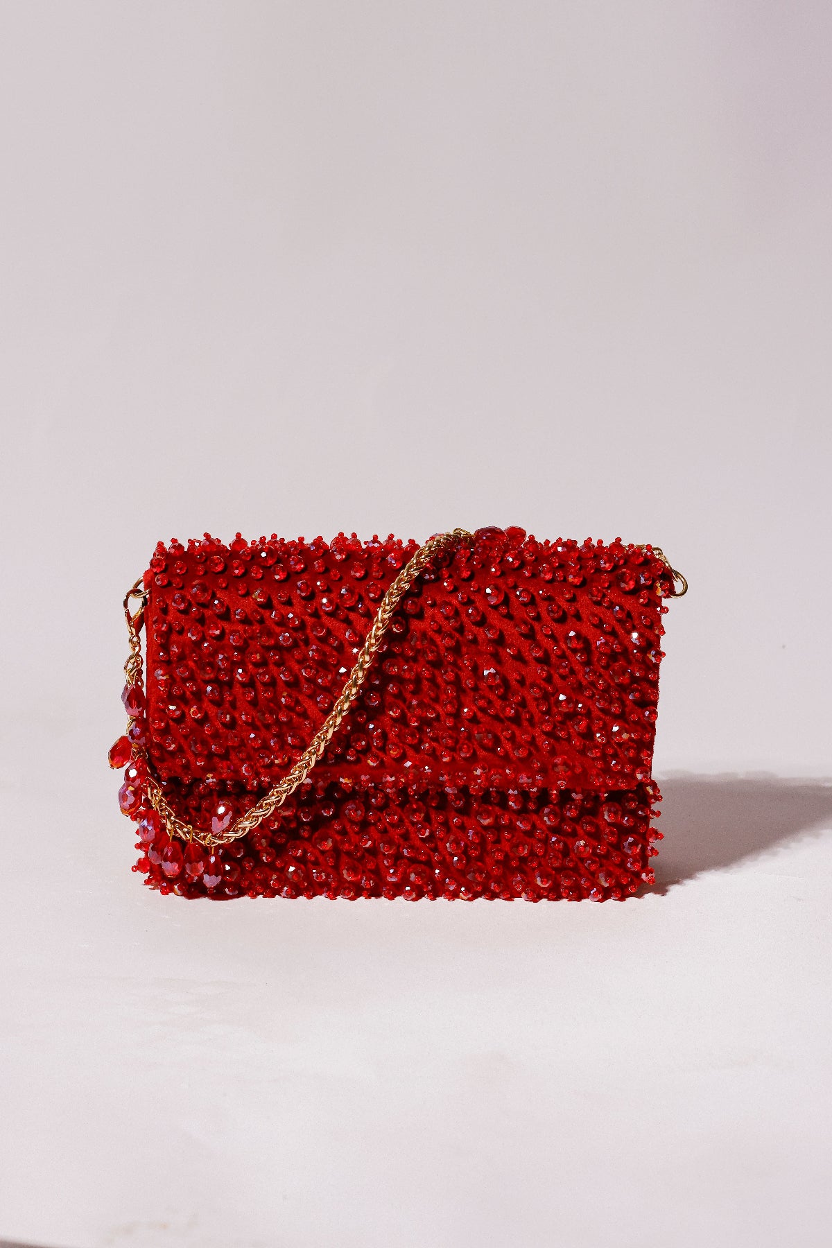 Red beaded handbag with a gold chain 
