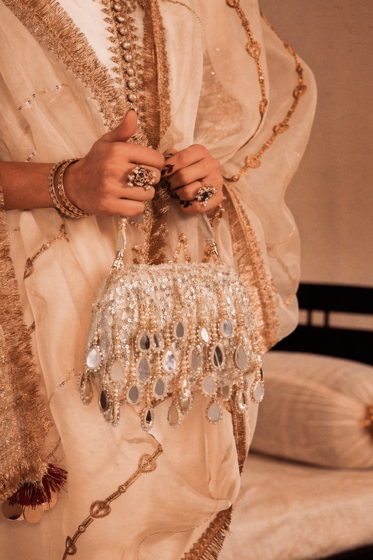 Silver shoulder bag featuring intricate beadwork and mirror embellishments