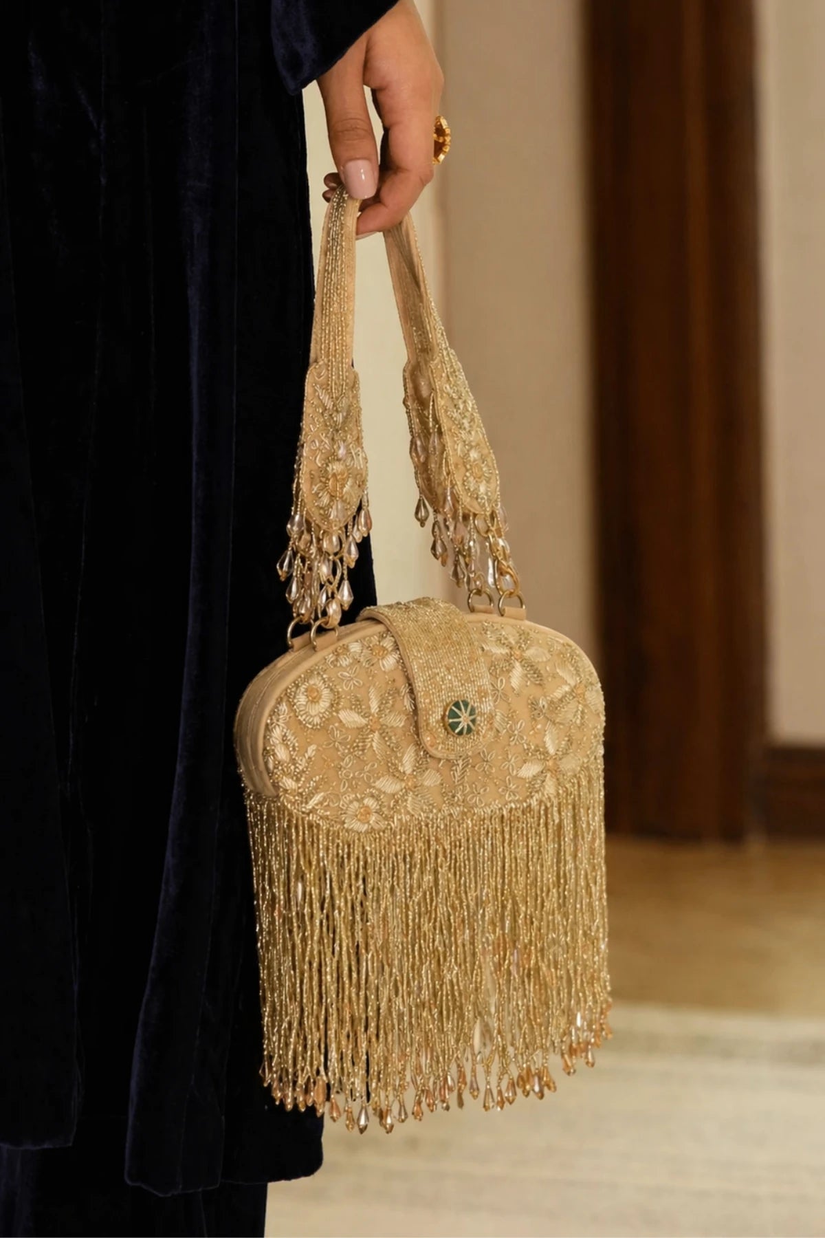 Luxury gold clutch bag paired with a traditional saree