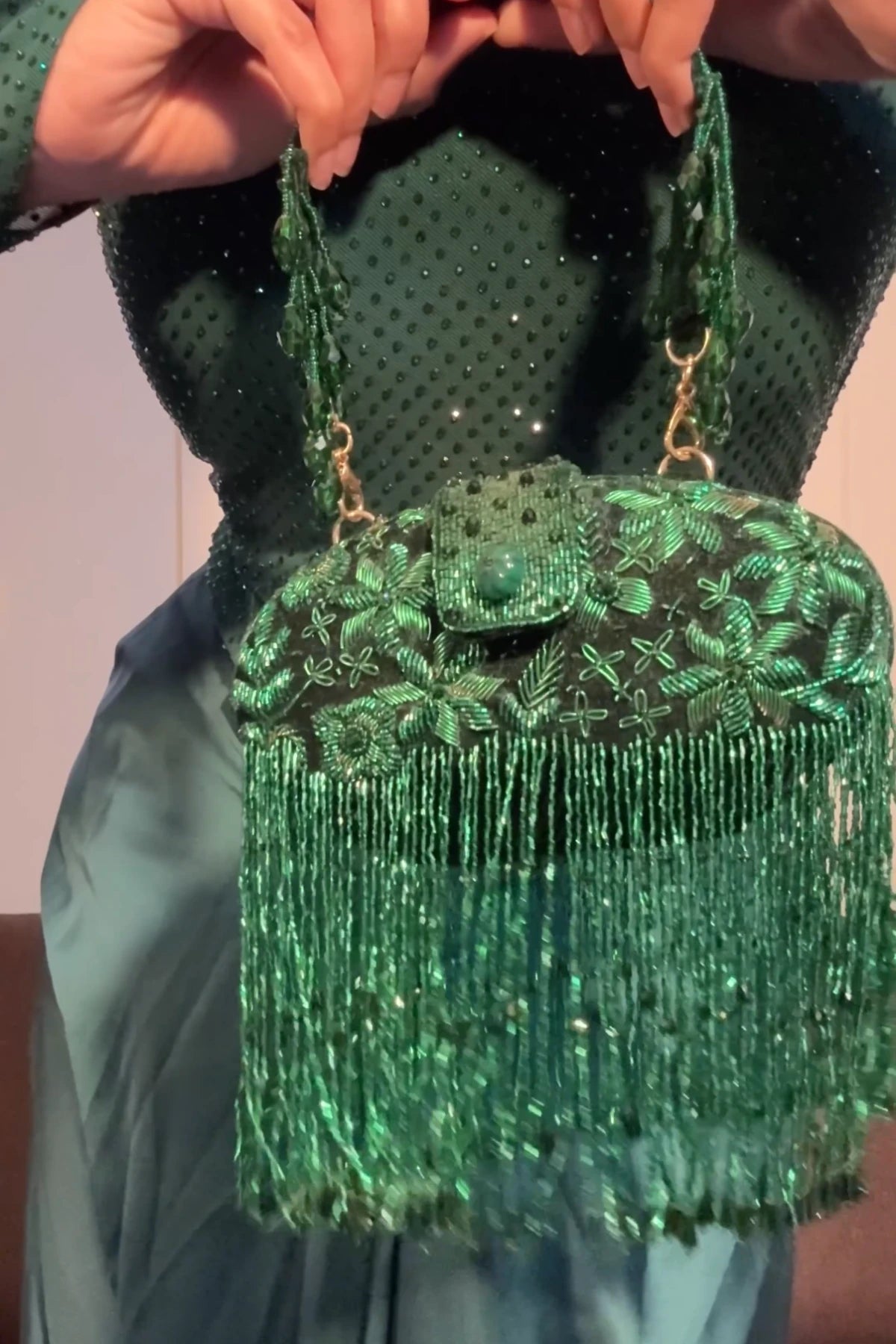 Luxury green clutch bag paired with a festive saree