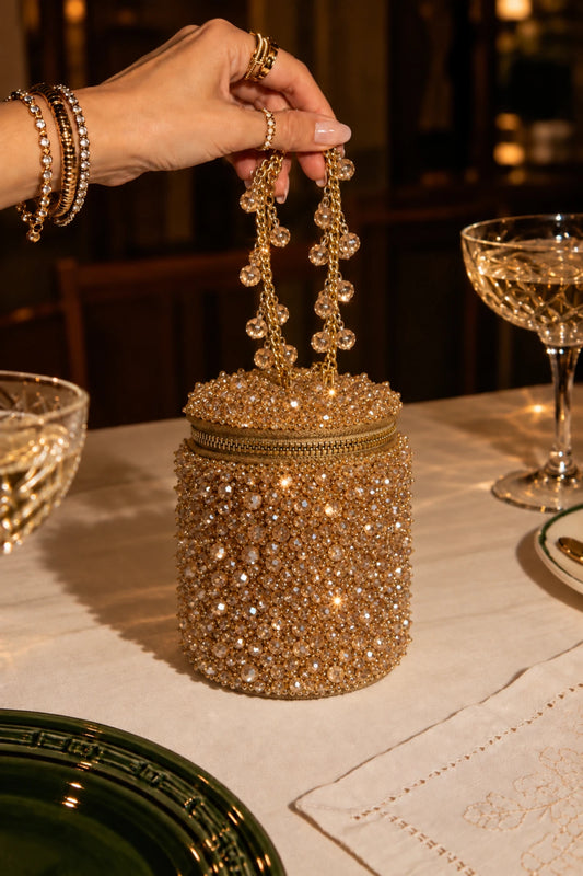 Nera Golden Bag featuring shimmering golden bead embellishments and a cylindrical silhouette, perfect for sangeet and cocktail parties.