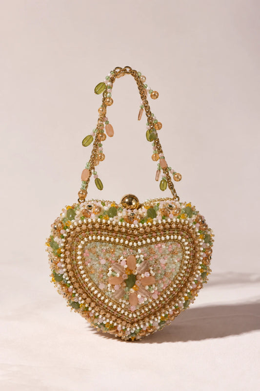 Designer heart-shaped handbag adorned with soft multicoloured pastel embellishments for elegant festive styling.