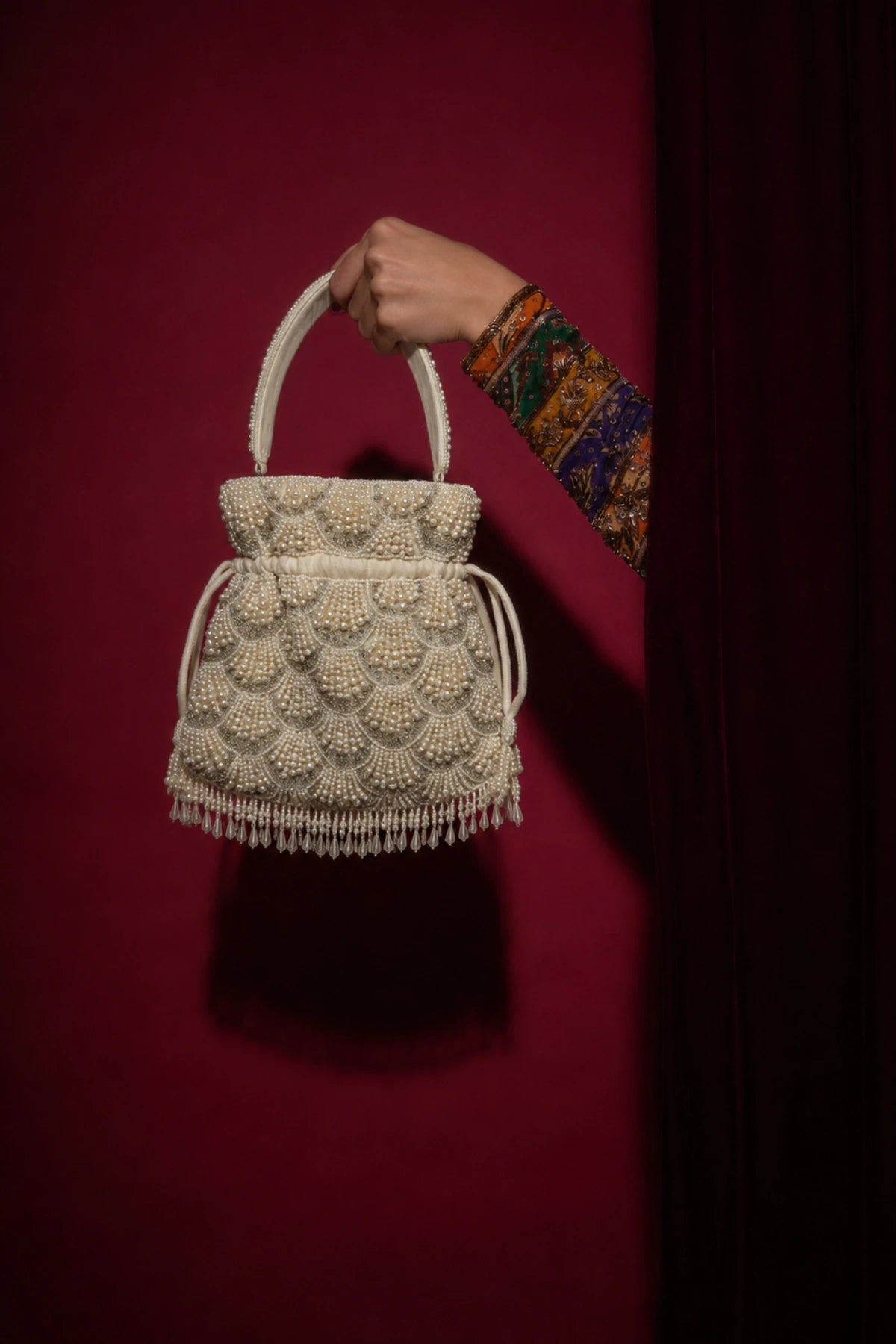 Pearl potli styled with a festive Mehendi lehenga