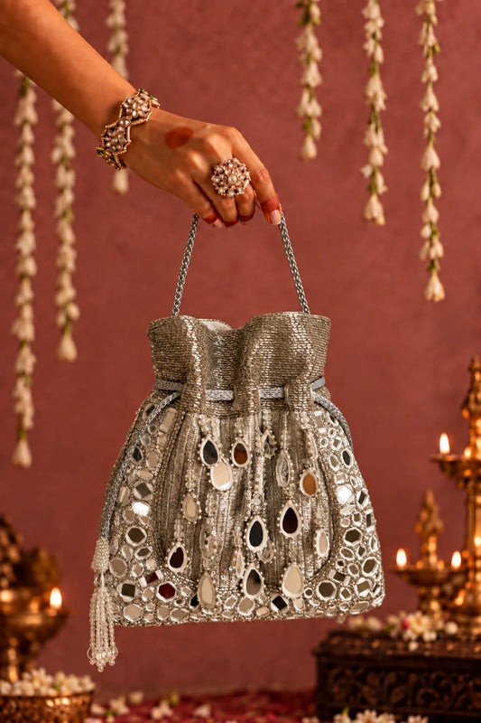 Roshni Mirror Silver Potli featuring intricate handcrafted mirror work on a shimmering silver base, perfect for festive celebrations.