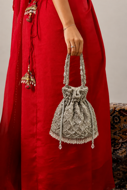 Silver potli bag styled with a lehenga for wedding functions