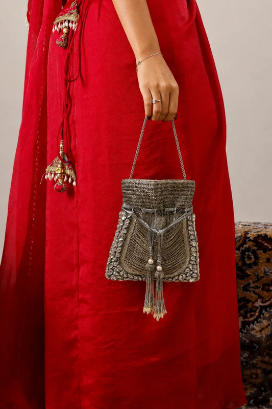 Silver potli bag paired with a saree for festive styling