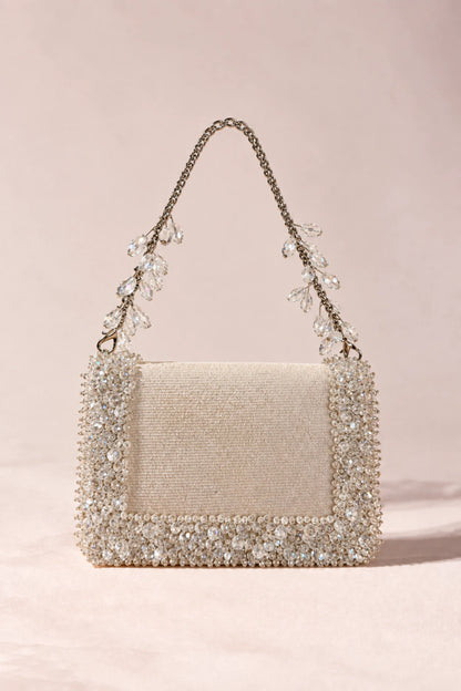Elegant white embellished handbag designed to complement resort wear, flowy dresses and contemporary vacation outfits.